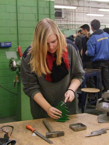 Foto einer Schülerin beim Bearbeiten eines Metall-Weihnachtsbaumes