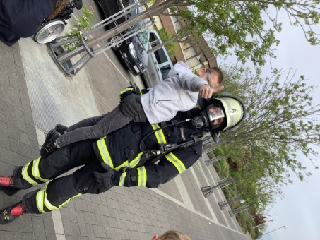 Ein Kind auf dem Arm des Feuerwehrmannes