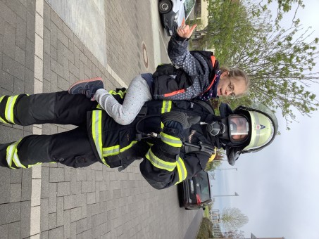 Ein Kind auf dem Arm des Feuerwehrmannes